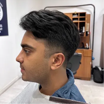 Men’s side-swept haircut with a tapered fade